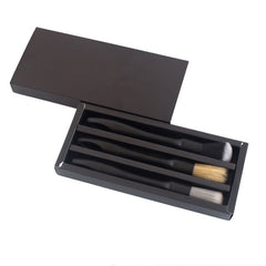 The black drawer box of the brush set with the lid taken off, the three brushes in their compartments.