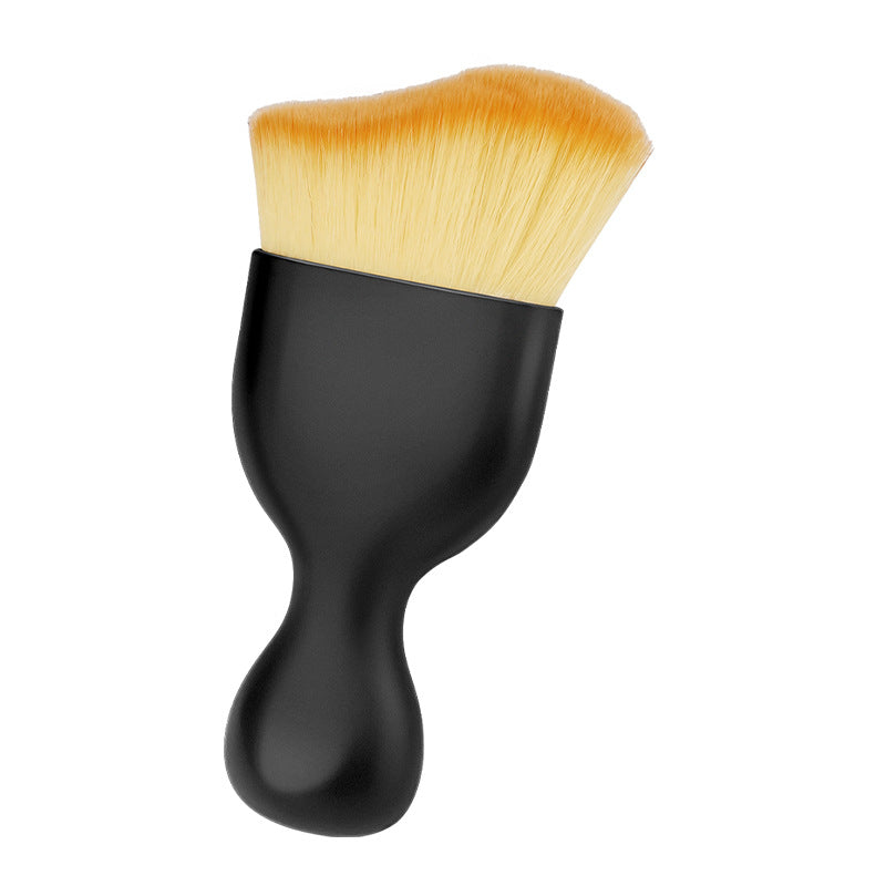 The gap brush: a contoured black handle with a wide, soft tan bristle head, on a white background.